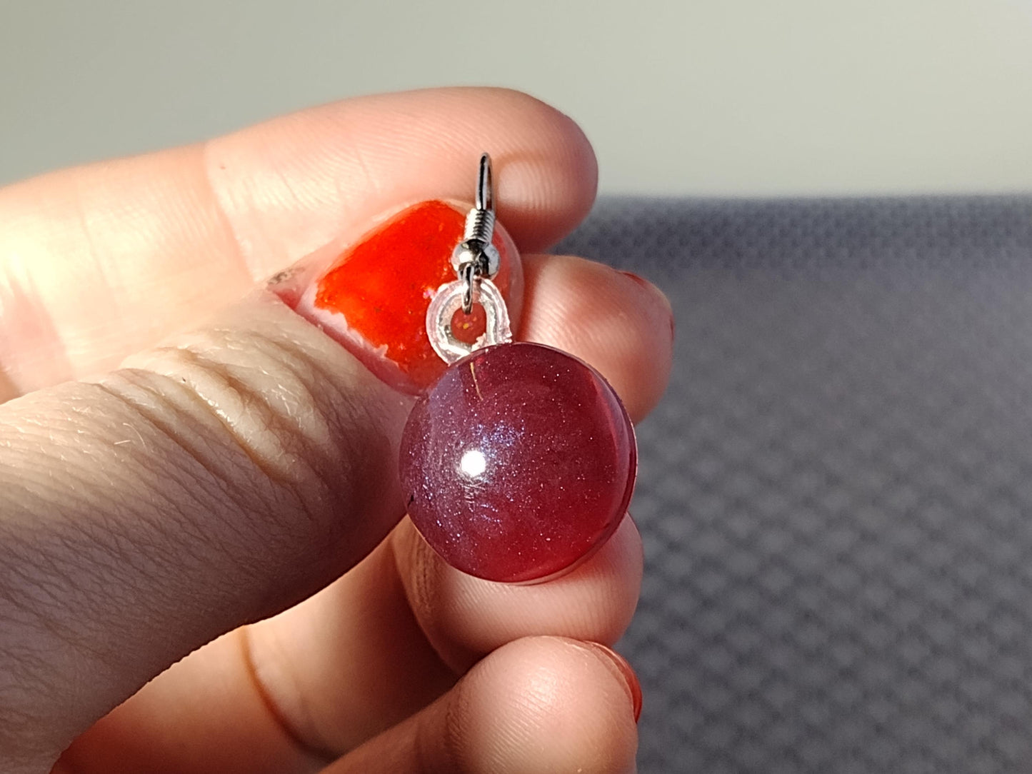 Round dark red resin earrings with blue shimmer shift